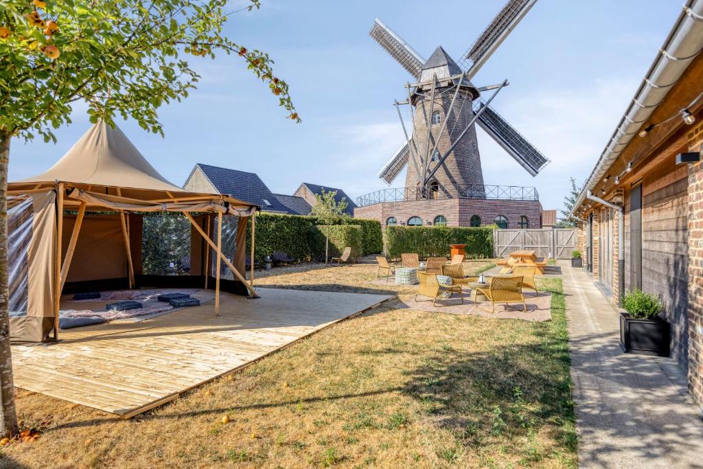 Buitenruimte van Molen de Hoop met loungetent op een houten vlonder en de molen op de achtergrond